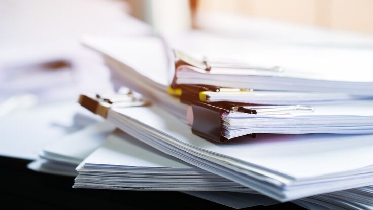 Stack of papers documents in archives files with clip papers on table at offices, Busy offices and Pile of data unfinished folders on office desk indoor near window, Business concept.