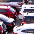 Car parked at concrete parking lot of shopping mall in holiday. Aerial view of car parking area of the mall. Automotive industry. Automobile parking space. Global automobile market concept.