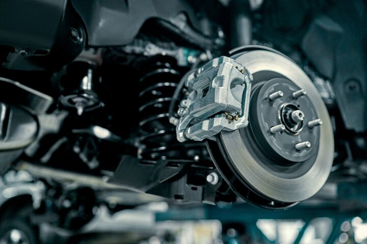 Disc brake of the vehicle for repair, in process of new tire replacement. Car brake repairing in garage.Suspension of car for maintenance brakes and shock absorber systems.Close up.