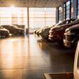 Stock of cars in showroom of automobile dealer with sunlight from window