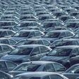 Rows of a new cars parked in a distribution center on a car factory on a sunny day. Parking in the open air.