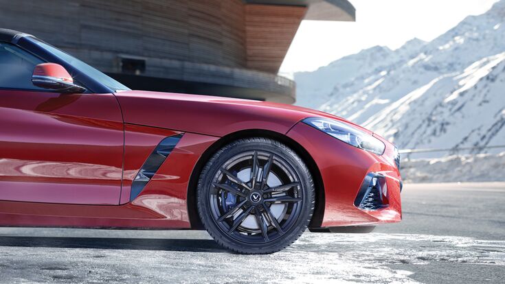 Rotes Auto vor verschneiter Bergkullisse