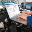 Automechaniker diagnostiziert mit Laptop