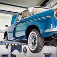 auto blau hebebühne prüfen wechseln nachschauen tüv dekra winterreifen sommerreifen schrauben reparatur reparaturwerkstatt fachwerkstatt inspektion schraubenlösen luftdruck kfz-werstatt werkstatt hoch sicherheit stehend angestellter auszubildener oldtimer verantwortung halle dreck öl öl verschmiert countrypixel