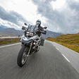 Motorbiker riding in Austrian Alps, dramatic sky. Travel and freedom, outdoor activities
